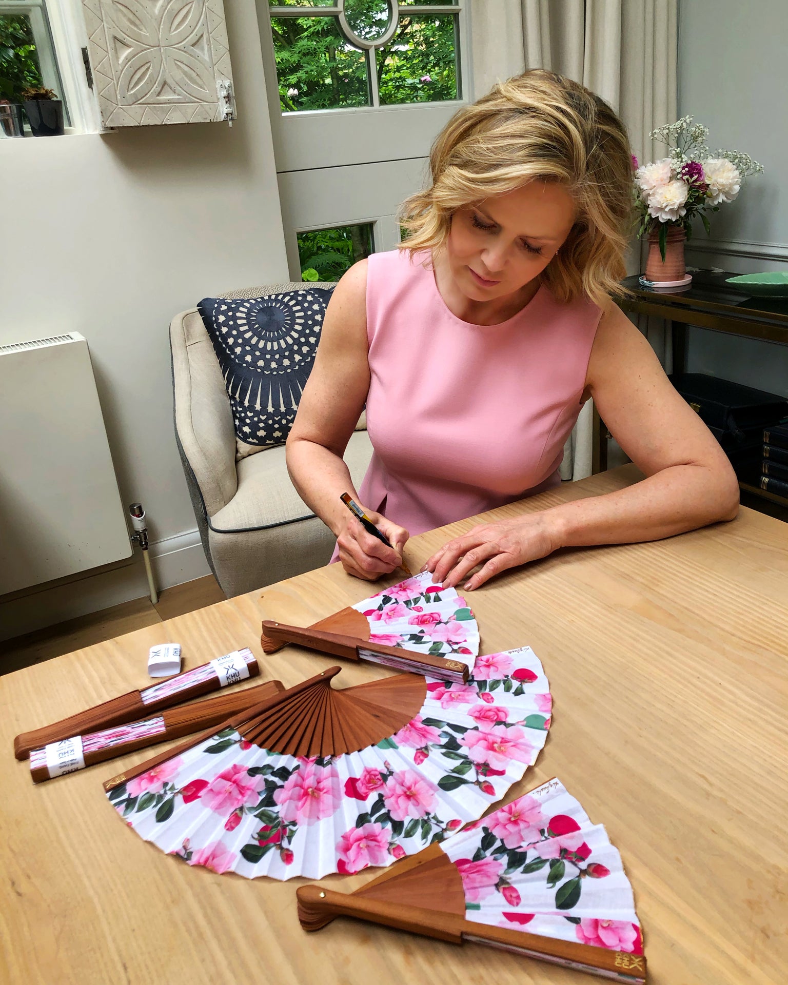 Liz Earle signing  Khu Khu Beautiful Cool Camellias Hand-Fan with collaboration print (Floral with pink and green spots and camellias.)